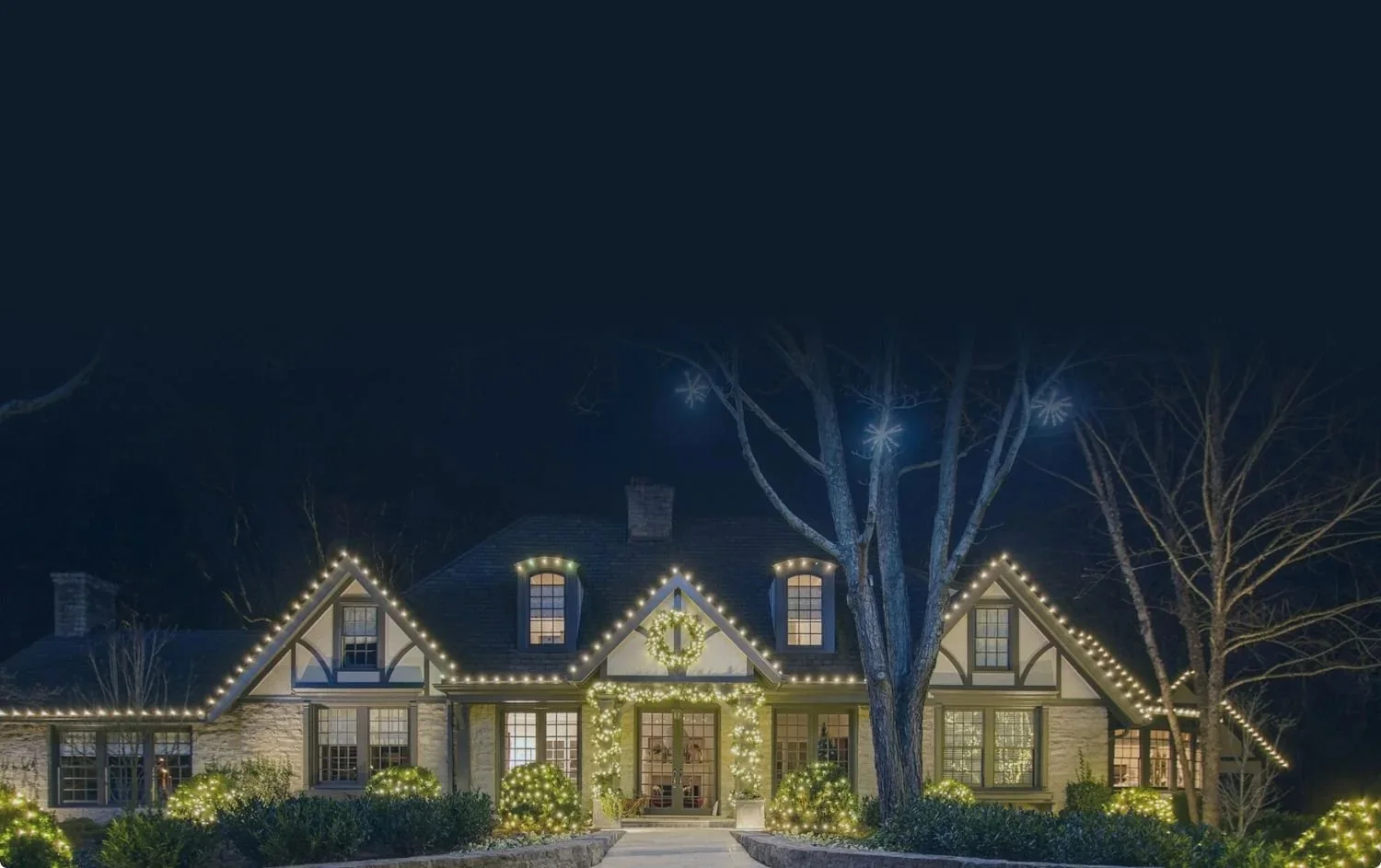 A home decorated with warm white roofline and landscape Christmas lights